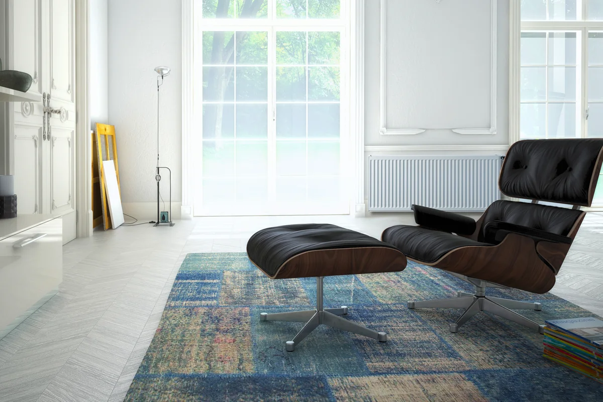 Brugman steel panel radiator under a window in a bright living room
