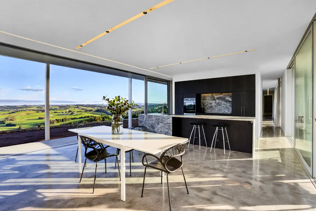 Dining table on polished concrete with afternoon sun across the floor