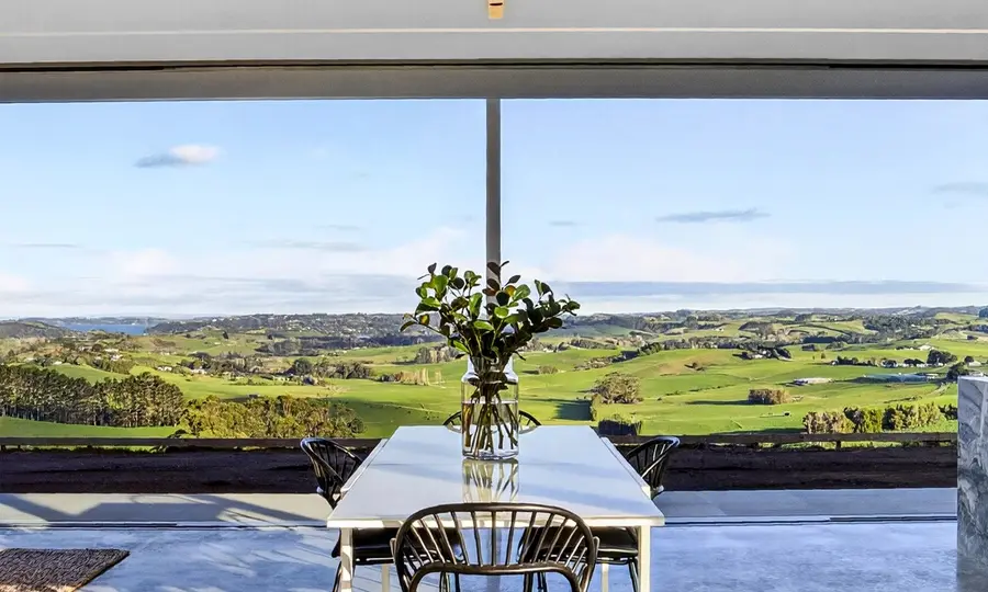 Living area with polished concrete floor and rural view, Matakana