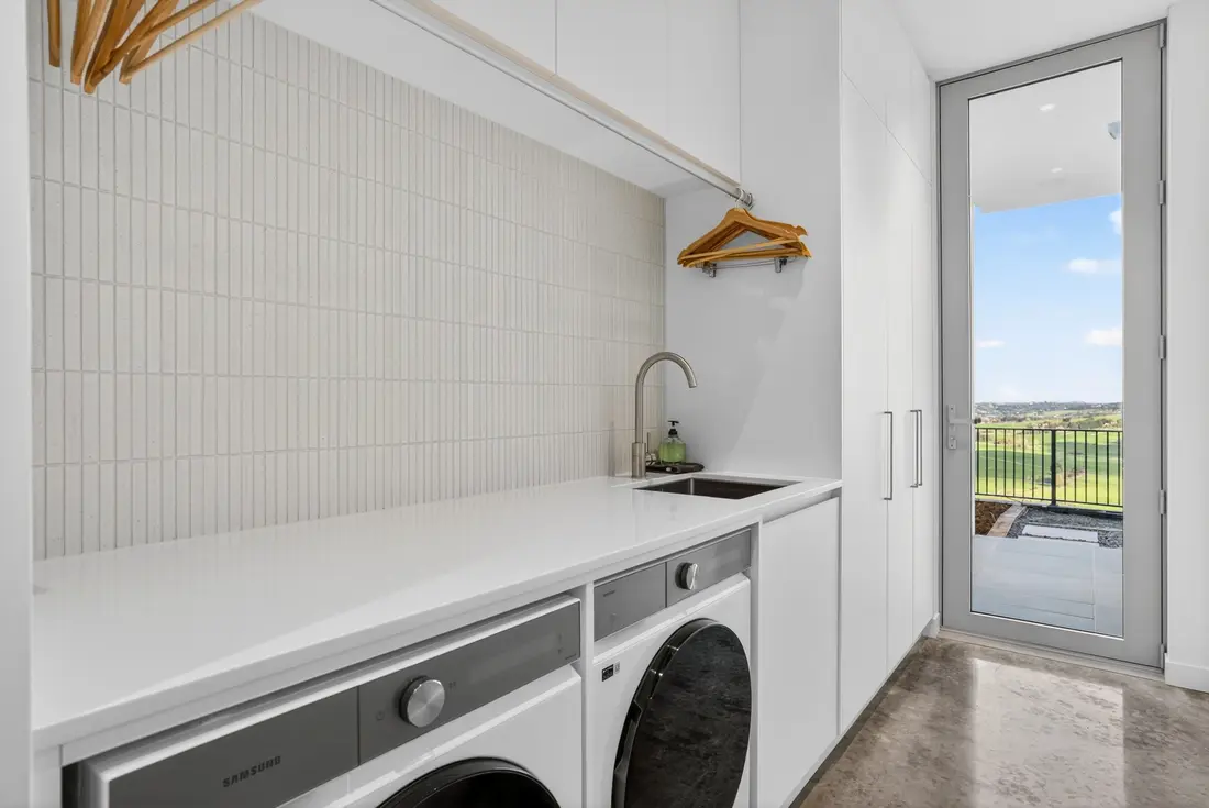 Laundry with polished concrete floor and door to the terrace